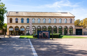 Façade principale de l’Arsenal de Metz, bâtiment culturel en pierre, photographié par temps clair avec une grande esplanade au premier plan.